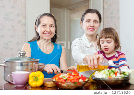 women with baby girl cook veggie lunch women with baby girl cook veggie lunch 12715620
