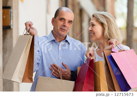 Aged couple with purchases 12715673