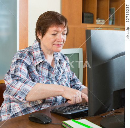 Senior woman using keyboard 12716237