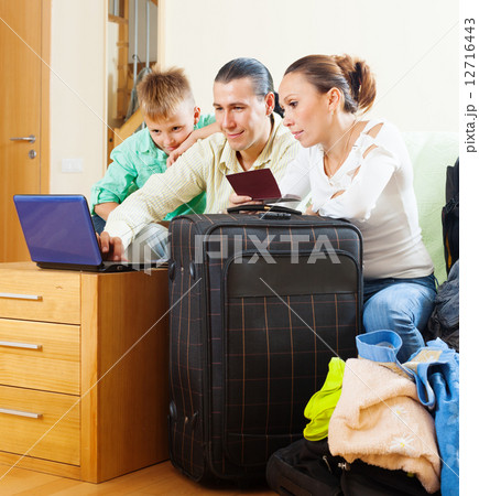 Happy family of three reserving resort on internet Happy family of three reserving resort on internet 12716443