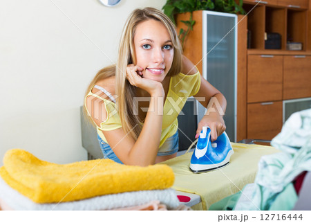 Young woman ironing with iron Young woman ironing with iron 12716444