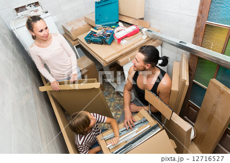 Family unpacking boxes with new furniture Family unpacking boxes with new furniture 12716527
