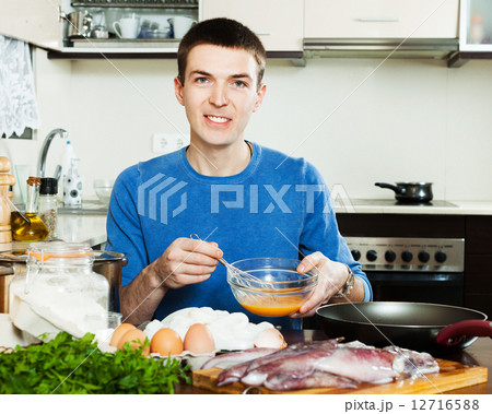 Happy guy frying calamari rings 12716588