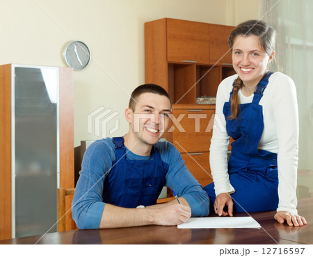 Happy smiling young workers in uniform with financial documents Happy smiling young workers in uniform with financial documents 12716597