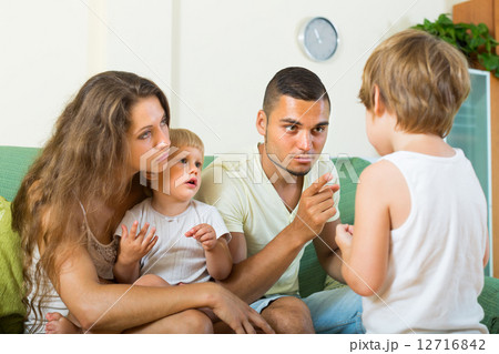 Parents scolding child in home Parents scolding child in home 12716842