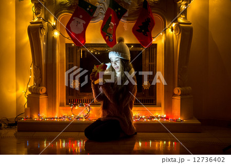 girl sitting next to extinguished fireplace and looking at Chris 12736402