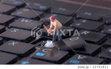 Miniature worker with pickaxe working on keyboard Miniature worker with pickaxe working on keyboard 12741811