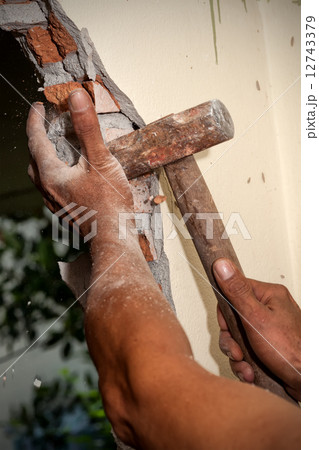 Worker breaking wall 12743379