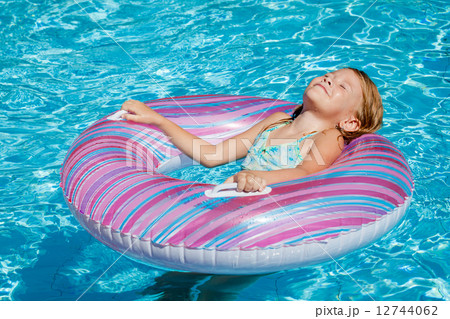 little girl lying on the inflatable rubber circle in the swimm little girl lying on the inflatable rubber circle in the swimm 12744062