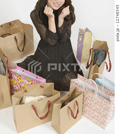 沢山の買い物袋に囲まれる若い女性 沢山の買い物袋に囲まれる若い女性 12746545