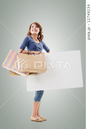 Shopping woman holding bags and blank board Shopping woman holding bags and blank board 12749234