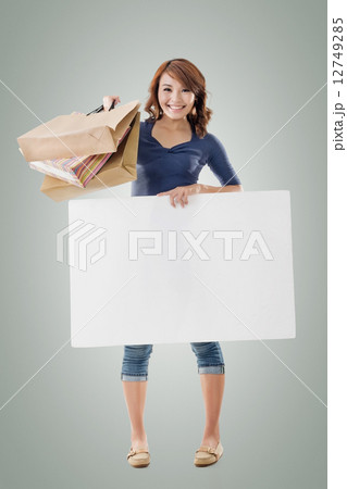 Shopping woman holding bags and blank board 12749285