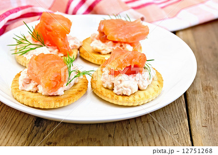 Crackers with cream and salmon on board 12751268