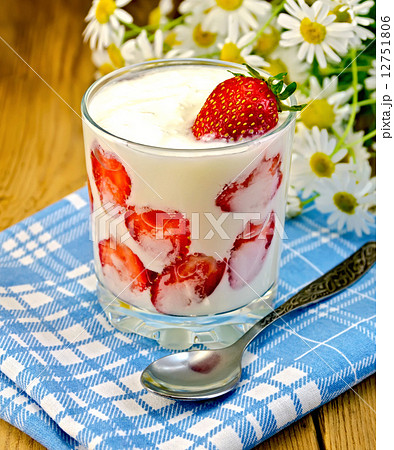 Yogurt thick with strawberries and daisies on board 12751806