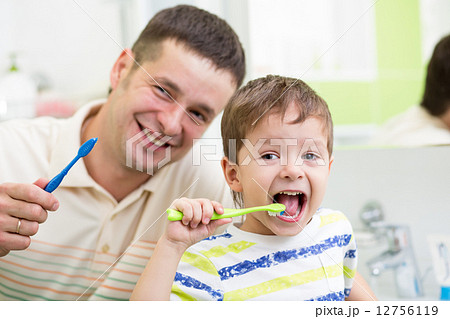 dad and kid son brushing teeth in bathroom 12756119