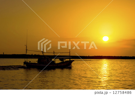 酒田港・夕陽と舟航する漁船 12758486