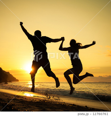 Happy family jumping on the beach at the dawn time Happy family jumping on the beach at the dawn time 12760761