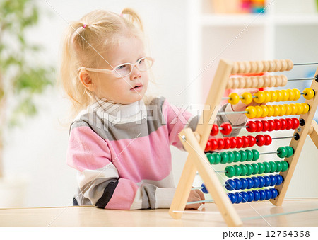 Funny kid in eyeglases counting using abacus 12764368