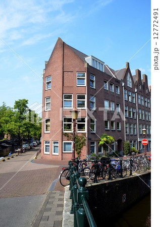 Corner house and many bikes on canal in Amsterdam, Holland 12772491