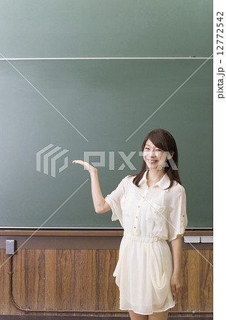 黒板の前に立って紹介をする女性 12772542