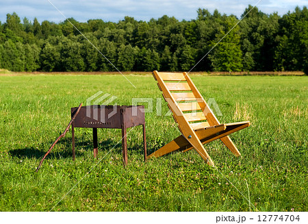 Armchair and barbecue outdoors 12774704
