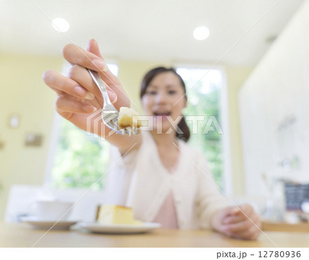 ケーキをのせたフォークを差し出す女性の手 ケーキをのせたフォークを差し出す女性の手 12780936