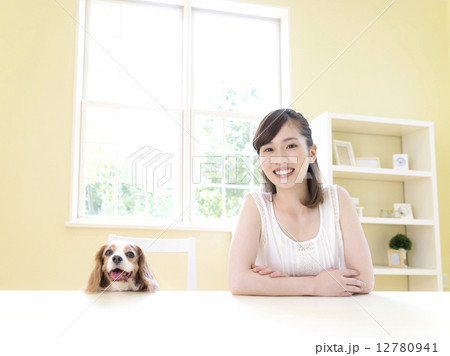 テーブルに向かう女性と犬 12780941