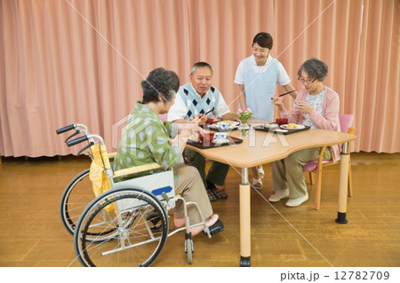 老人ホームで食事するシニアと介護福祉士 12782709