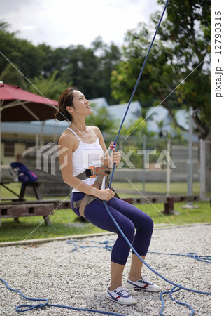 Asian Woman in belaying stance in outdoor rockclimb 12790316