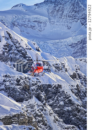 Red helicopter landing at swiss alps near Jungfrau mountain Red helicopter landing at swiss alps near Jungfrau mountain 12794922