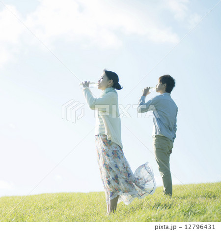 草原で水を飲むカップル 12796431