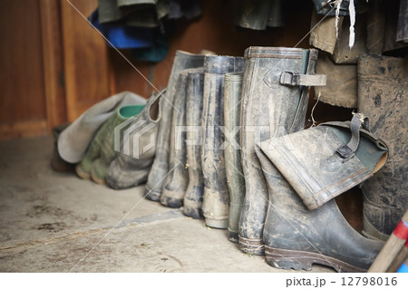 Several pairs of muddy wellington boots on a stone floor. Several pairs of muddy wellington boots on a stone floor. 12798016