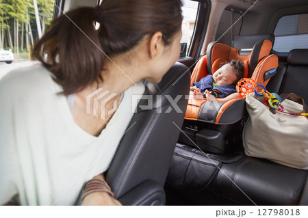 A mother and her young baby boy in a car. 12798018