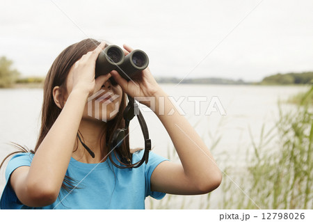A young girl, a birdwatcher with binoculars. 12798026