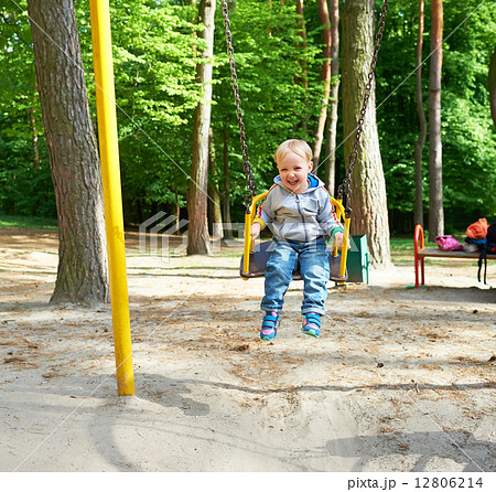 Happy little blond boy having fun on a swing. Happy little blond boy having fun on a swing. 12806214
