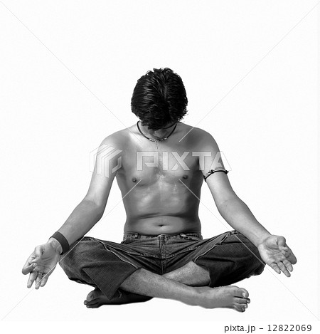 A young Indian modern man meditatin in lotus pose 12822069