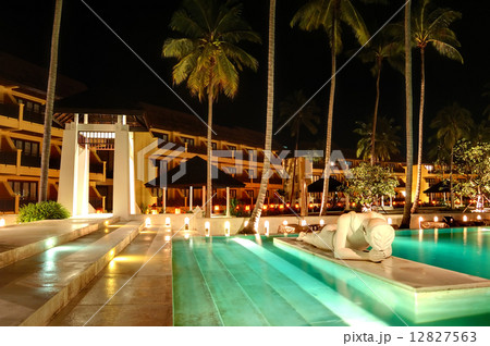 Modern swimming pool decorated with Buddha statue in night illum 12827563