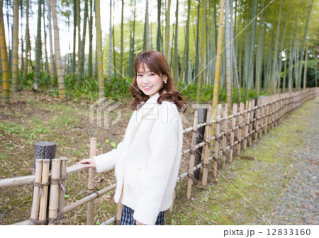 竹やぶを背景にする笑顔の若い女性 12833160
