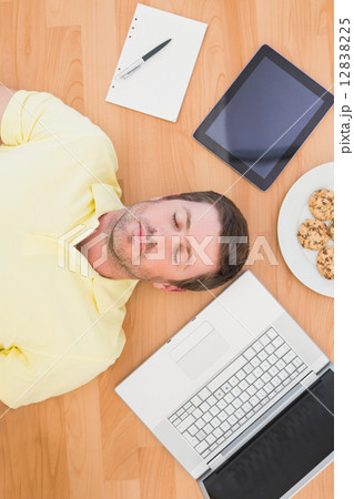 Man lying on floor surrounded by various objects at home Man lying on floor surrounded by various objects at home 12838225