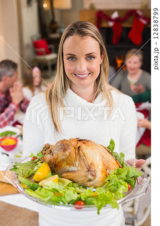 Portrait of a smiling woman showing the roast turkey 12838799