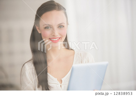 Pretty brunette using her tablet Pretty brunette using her tablet 12838953