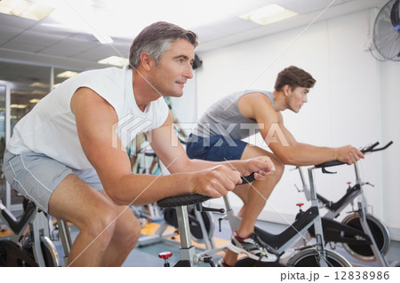 Fit people working out on the exercise bikes 12838986
