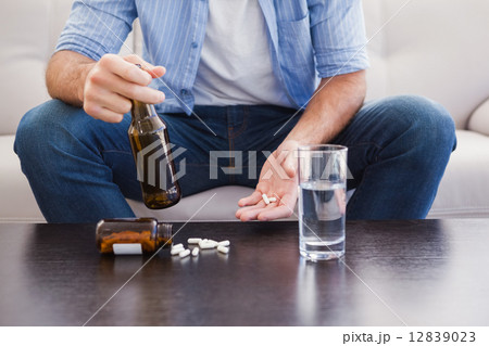 Close up of man showing pills and holding bottle Close up of man showing pills and holding bottle 12839023