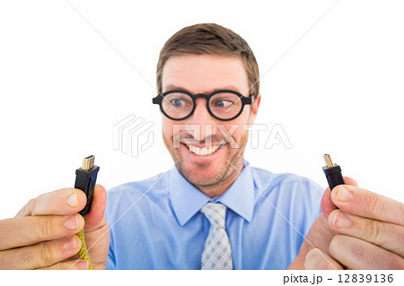 Geeky businessman holding two cables 12839136