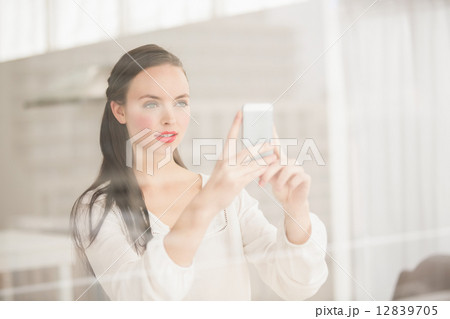 Pretty brunette taking photo on her phone 12839705