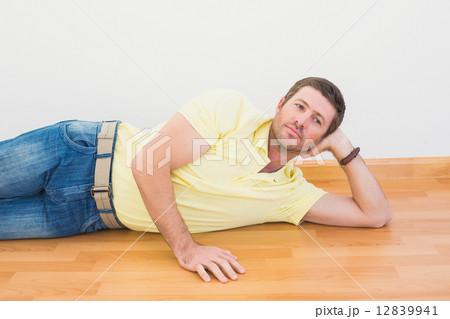 Man lying on floor at home Man lying on floor at home 12839941