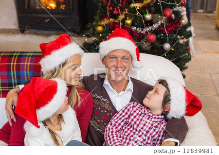 Festive family in santa hat hugging on couch Festive family in santa hat hugging on couch 12839981