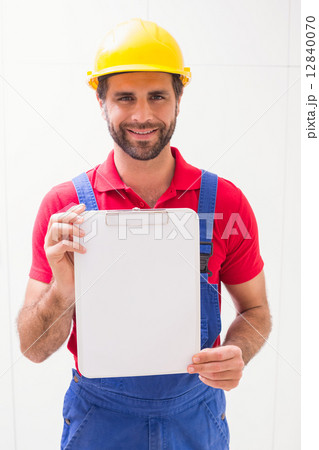 Construction worker showing clipboard to camera Construction worker showing clipboard to camera 12840070