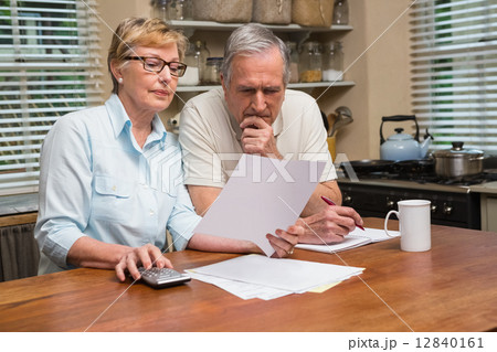 Senior couple working out their bills 12840161