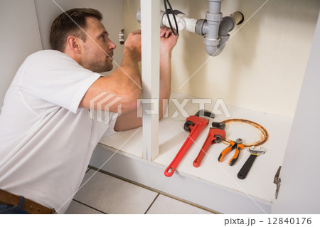 Plumber fixing under the sink Plumber fixing under the sink 12840176